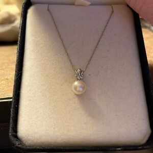 Single pearl necklace on silver chain.